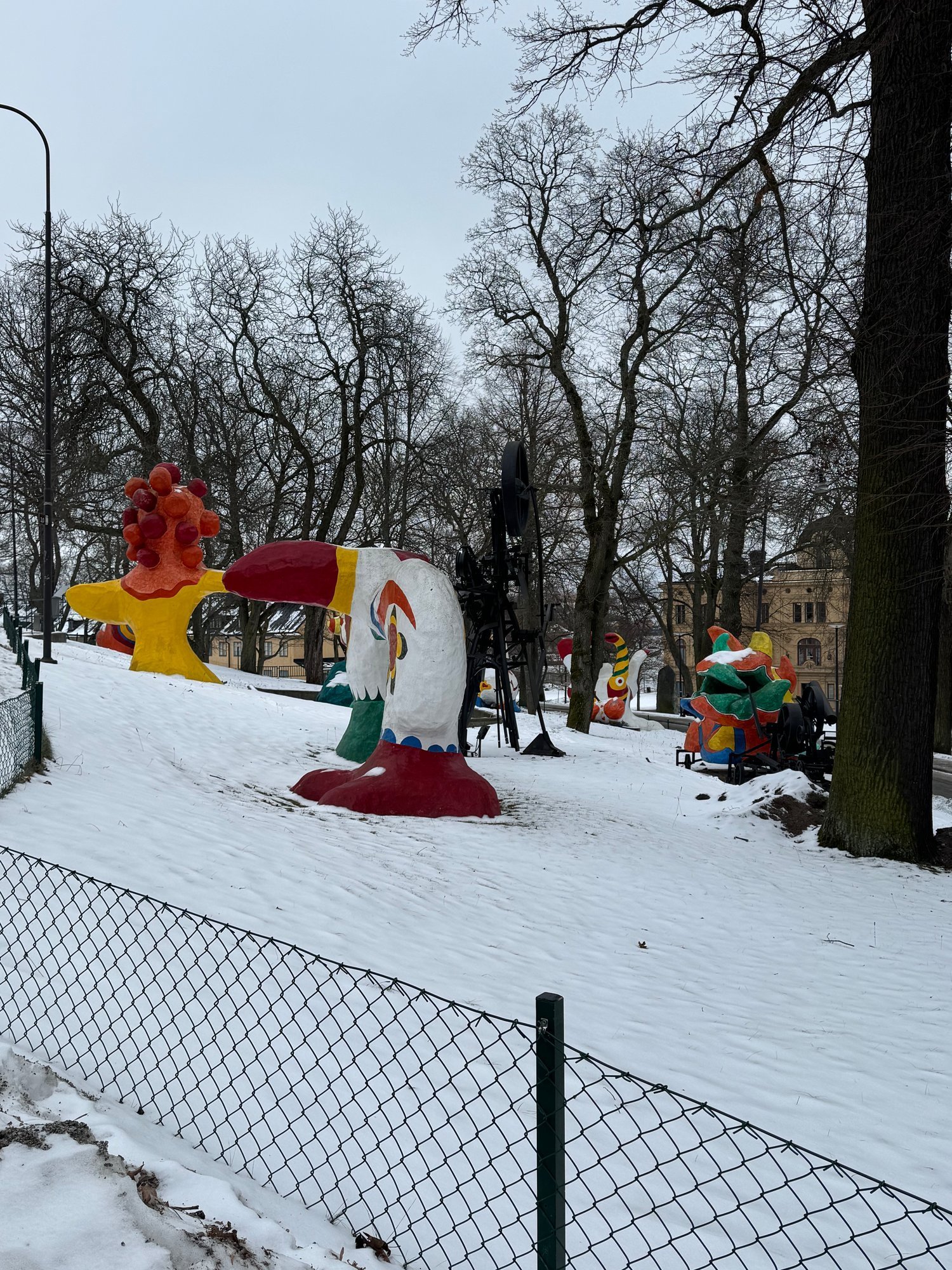 Colourful sculptures from The Paradise by Niki de Saint Phalle and Jean Tinguely in the snow outside Moderna Museet, Stockholm