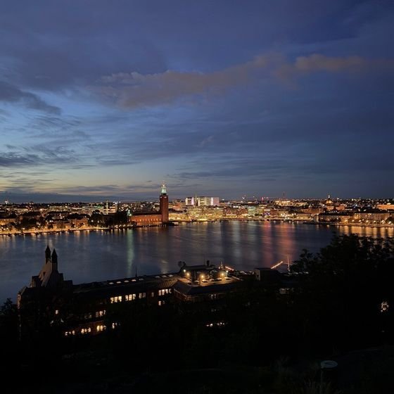 City lights reflect across the water in a night view of the Stockholm skyline, photographed by Zayera Khan