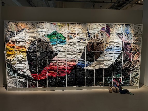 Large wall artwork made of old clothes in many colours