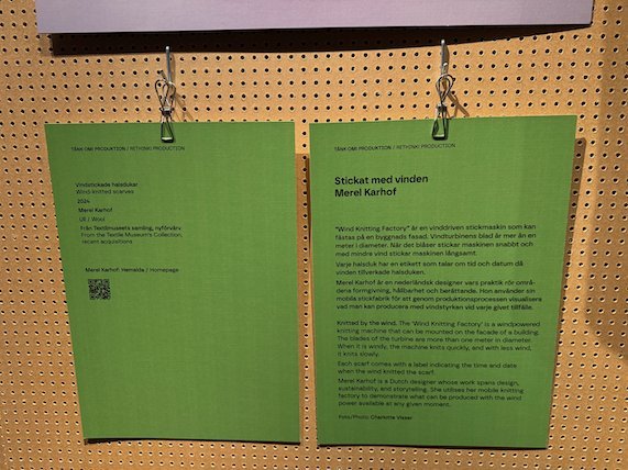 Green exhibition signs on a pegboard wall