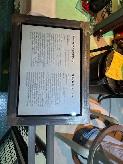 Exhibition sign about textile machines on a metal stand