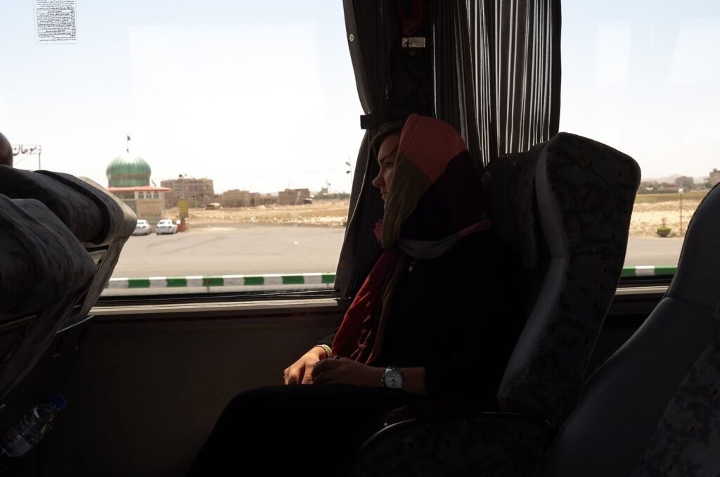 Traveler by the window of the tour bus on the road in Iran