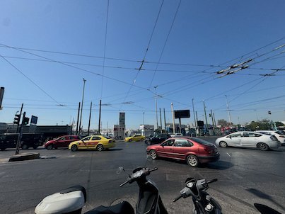 Cars, taxis and scooters on a busy street near the port of Piraeus