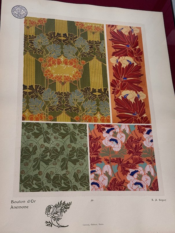 An Art Nouveau print with leaf and flower patterns hangs in an exhibition in Trier.