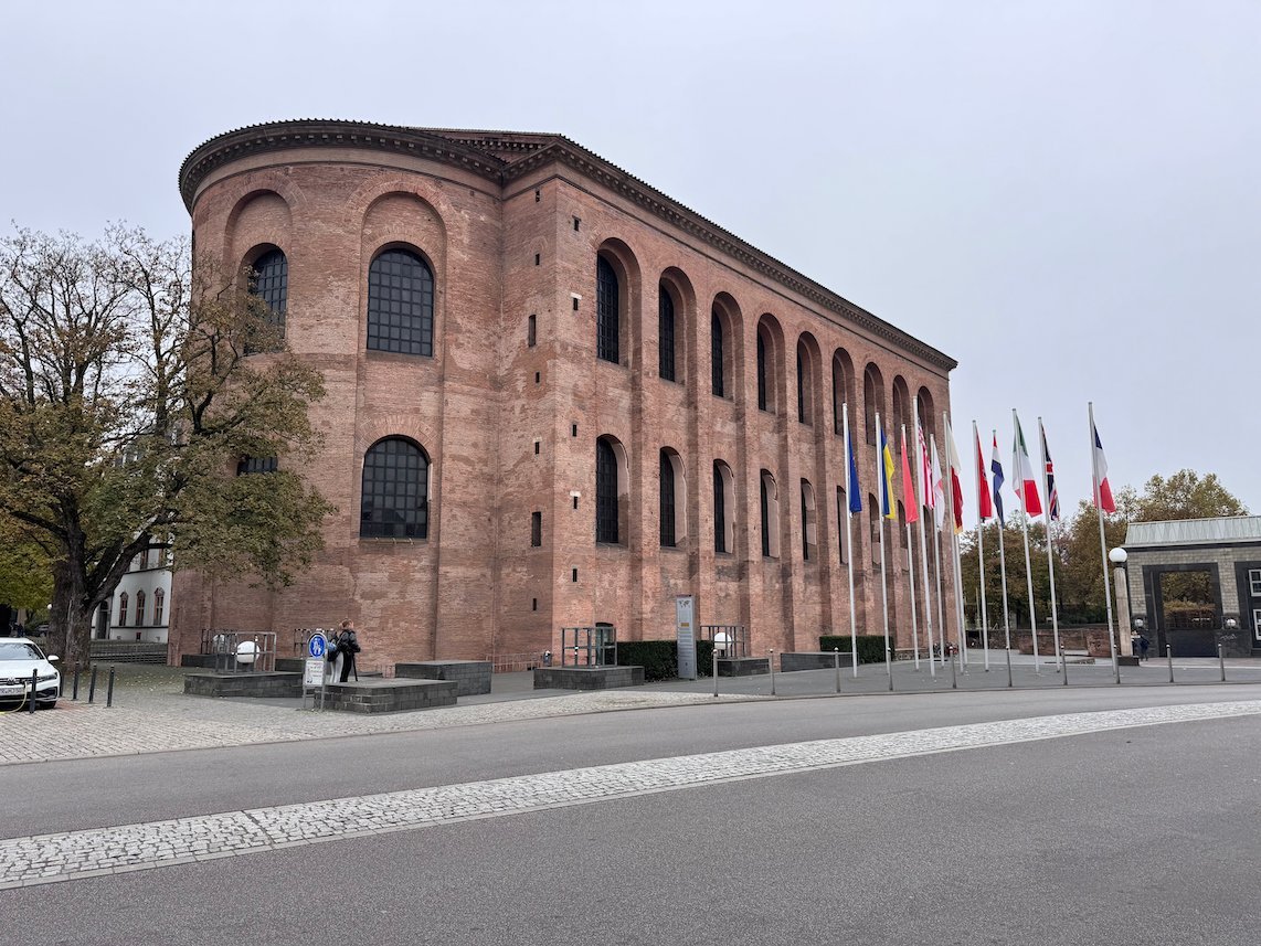 The tall brick walls of the Aula Palatina stand beside a square in Trier.