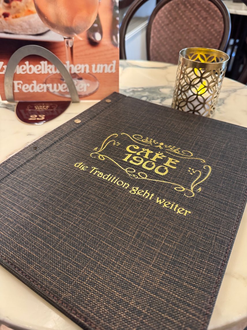 The menu of Cafe 1900 lies on a marble table in Trier.