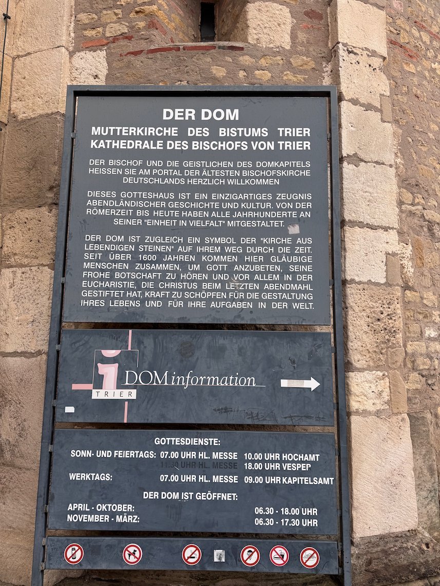 A sign at the entrance of Trier Cathedral gives information and mass times.