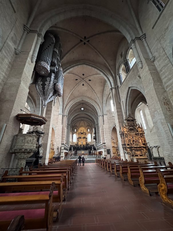 The nave of Trier Cathedral has a high organ and a carved pulpit.