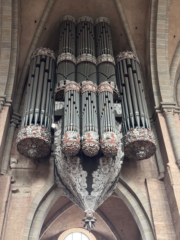 The organ hangs high on the wall like a nest inside Trier Cathedral.