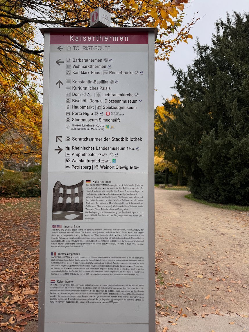 A signpost with directions stands at the Imperial Baths in Trier.