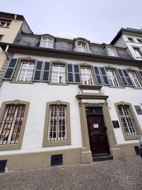 The white facade of the Karl Marx House museum stands on a street in Trier.