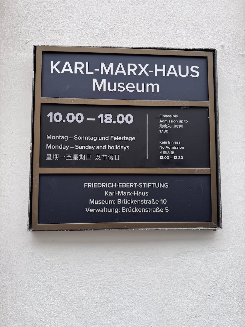 A sign gives the opening hours of the Karl Marx House museum in Trier.