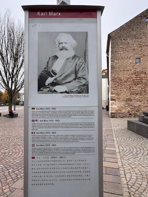 An information sign with a portrait of Karl Marx stands on a square in Trier.