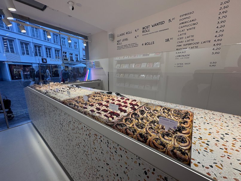 Rows of pastries lie on a long counter in a modern shop in Trier.