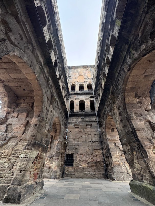 The high stone walls of the Porta Nigra courtyard rise on both sides in Trier.