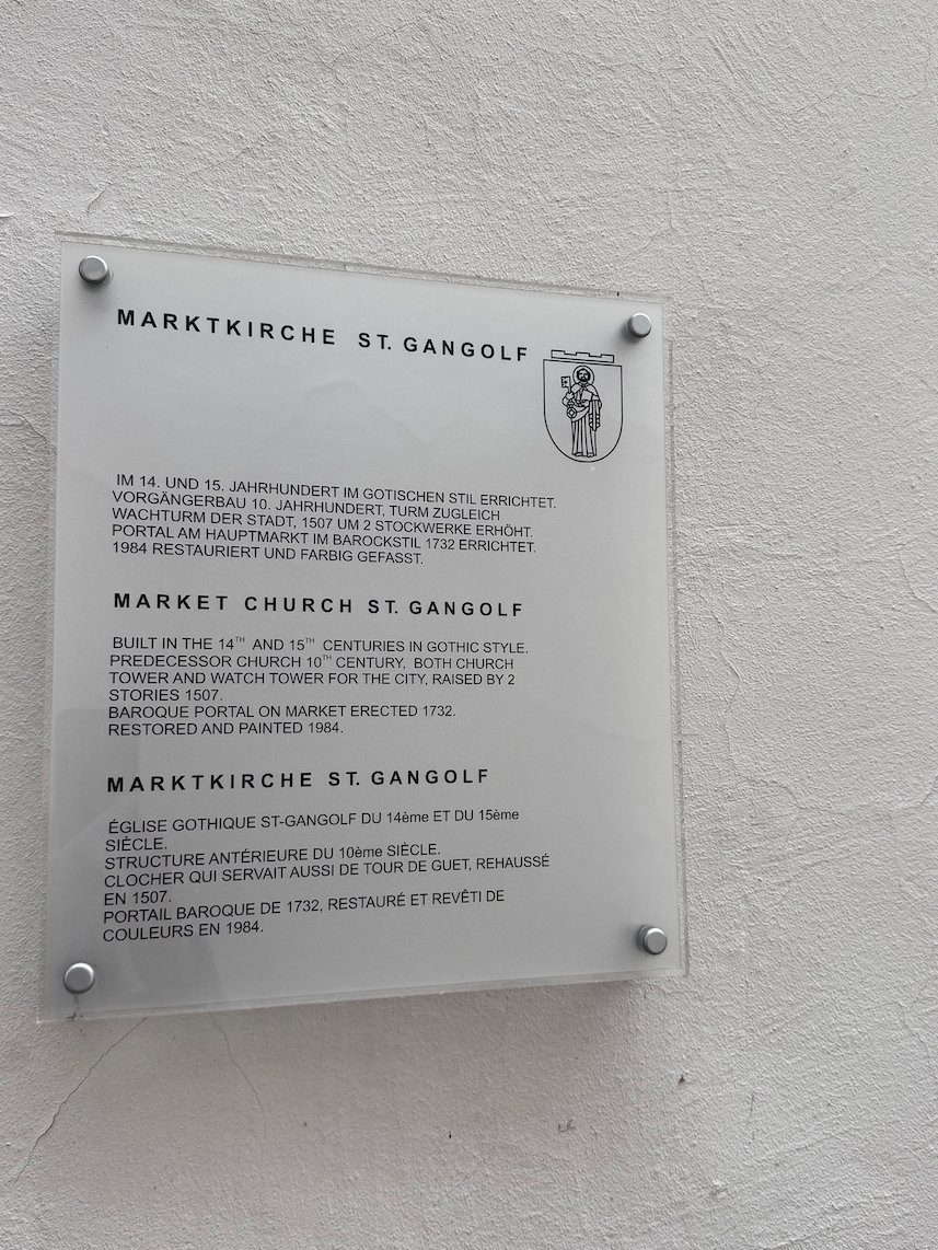 A sign tells the history of the market church of St. Gangolf in Trier.