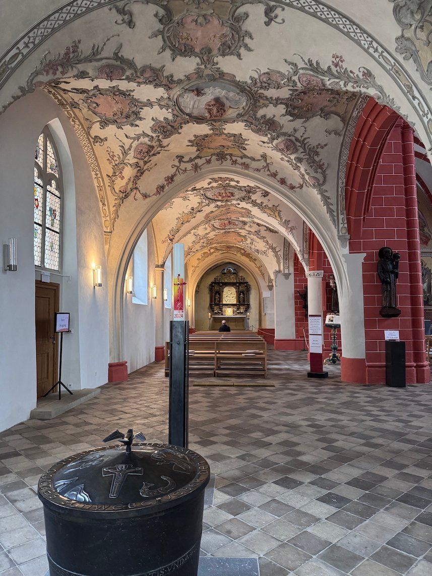 Painted vaults and red arches decorate a side aisle of St. Gangolf in Trier.