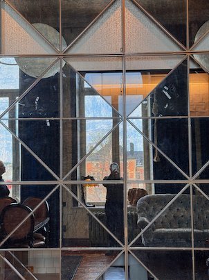 Mirror wall with diamond patterns in a hotel lounge with armchairs