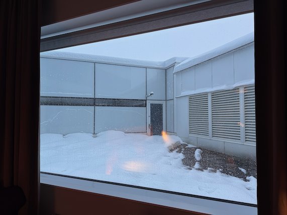 View through a hotel window into a snowy inner courtyard