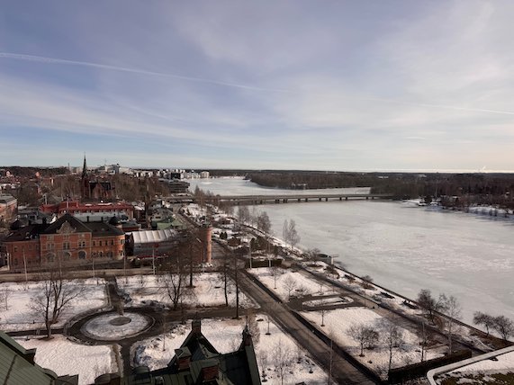 View over central Umeå, a snowy park and the frozen Ume River from a high building