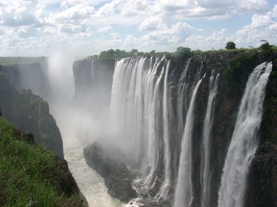 A long curtain of white water drops into the gorge at Victoria Falls in Zimbabwe.
