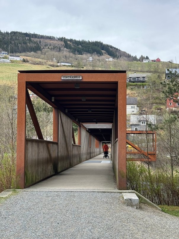 Covered wooden footbridge with a gravel path in Voss