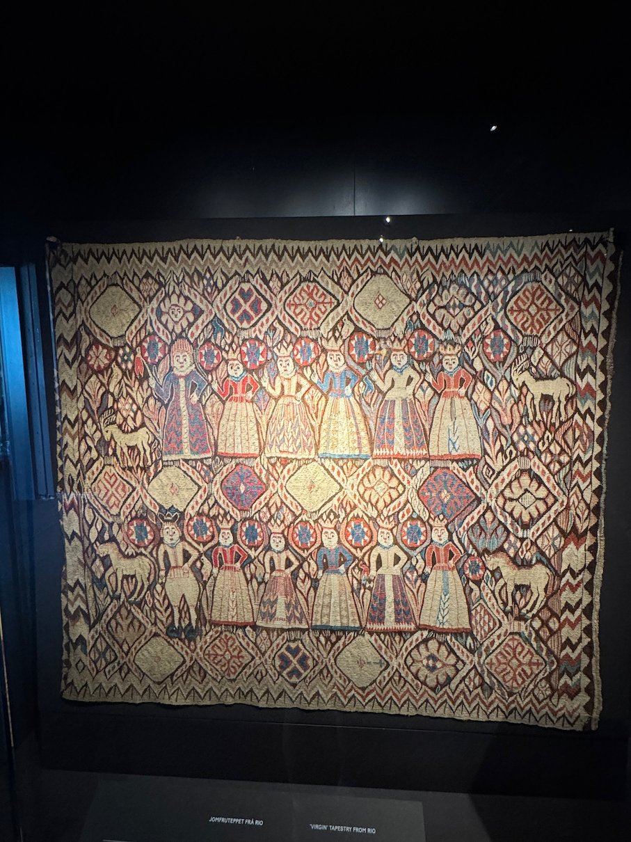 Old woven tapestry with figures and patterns in red, blue and white at Voss Folkemuseum
