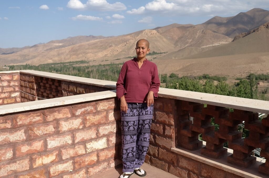 Zayera Khan on a brick terrace with the mountains near Abyaneh behind