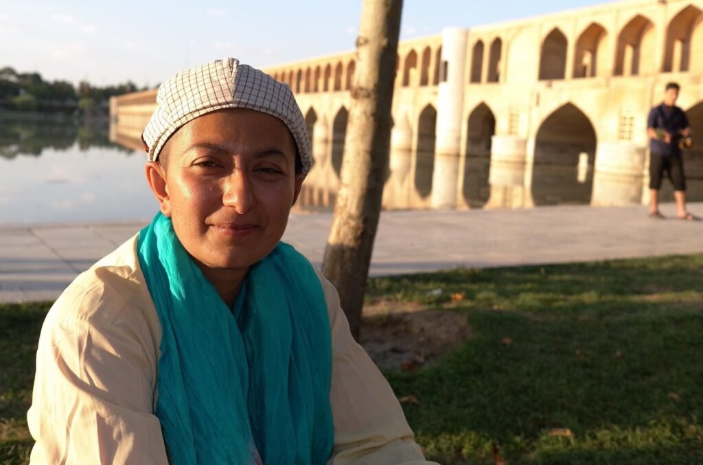 Zayera Khan in a cap and a turquoise scarf by Si-o-se-pol bridge in Isfahan