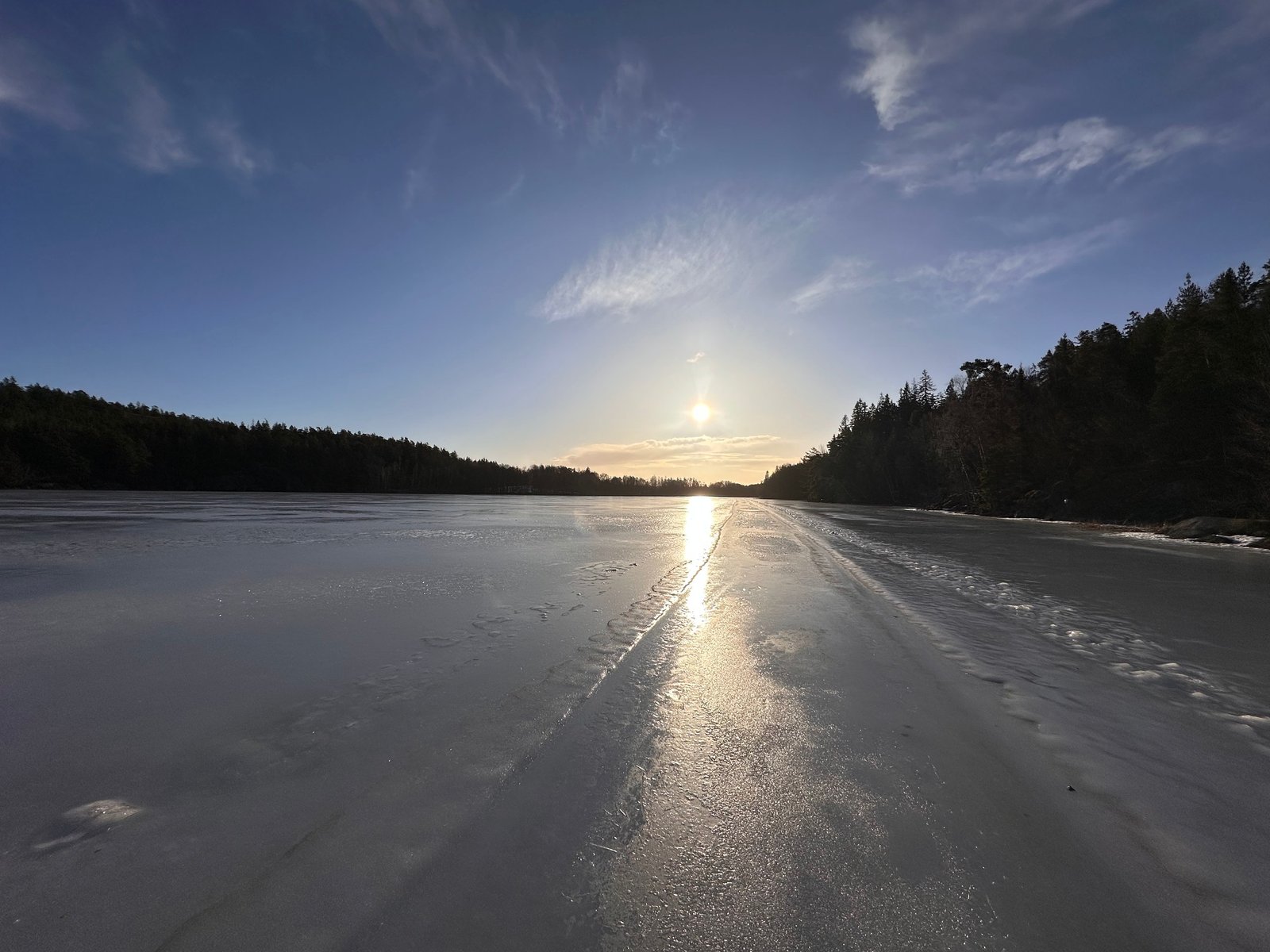 Sunset over a frozen lake in wintertime Sweden, photographed by Zayera Khan