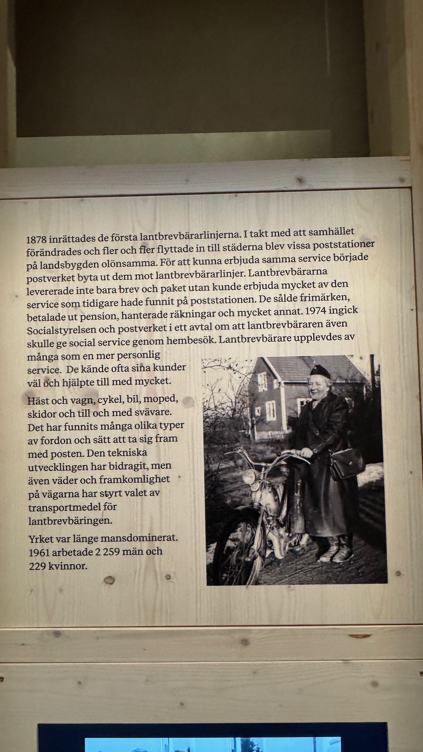 A museum information panel about Sweden's rural letter carriers, with a black-and-white photo of an elderly woman postal carrier standing beside her moped.
