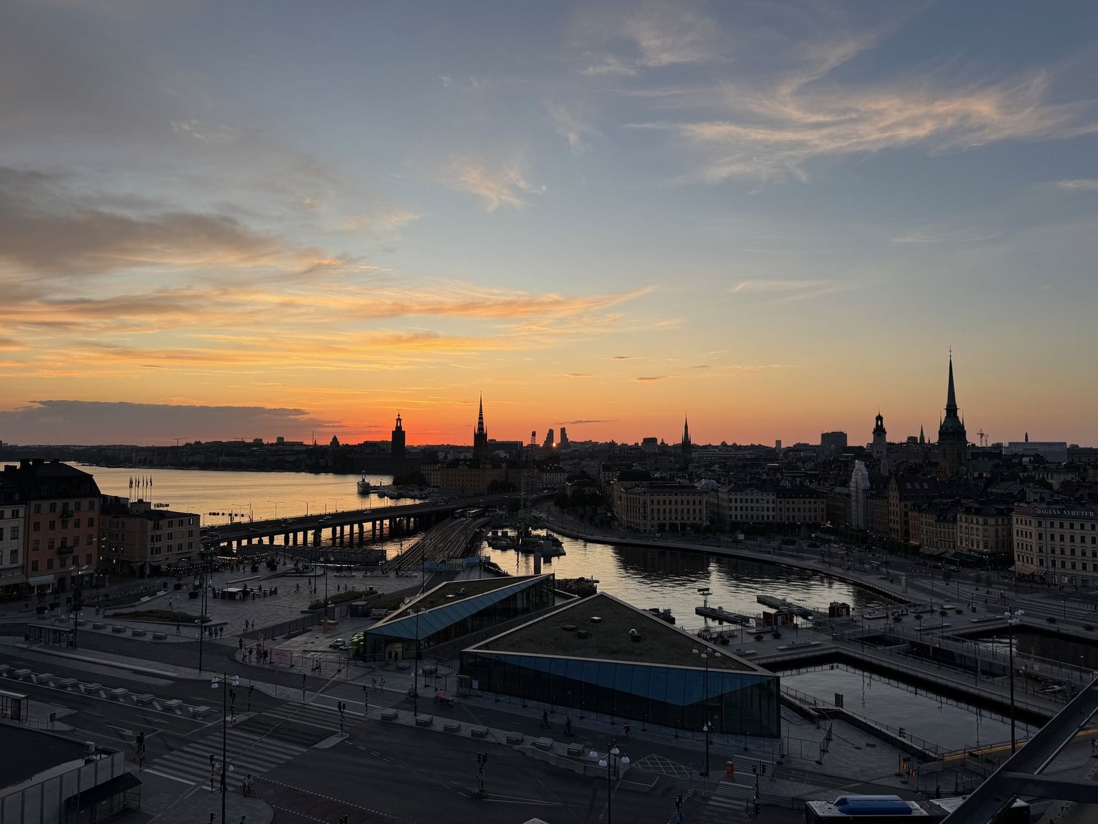 Sunset over Stockholm. The church spires of Gamla stan stand against an orange sky, seen from Slussen.