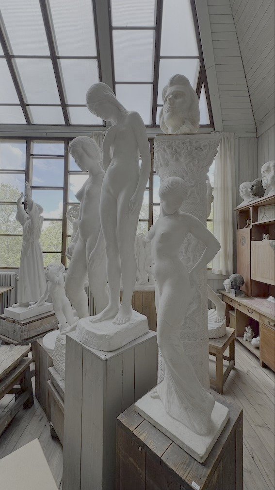 Studio hall at Carl Eldhs Ateljémuseum filled with plaster figures of young women, standing under a glass roof.