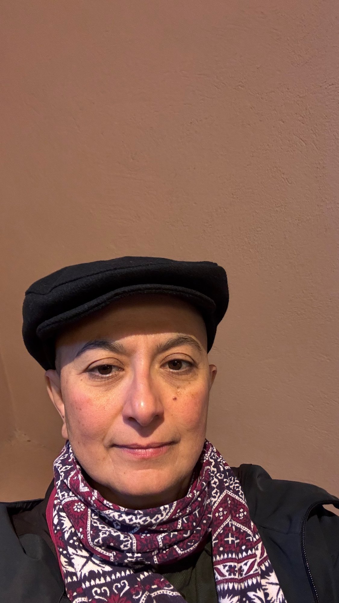 Zayera Khan in a black cap and a patterned scarf at Scenkonstmuseet.