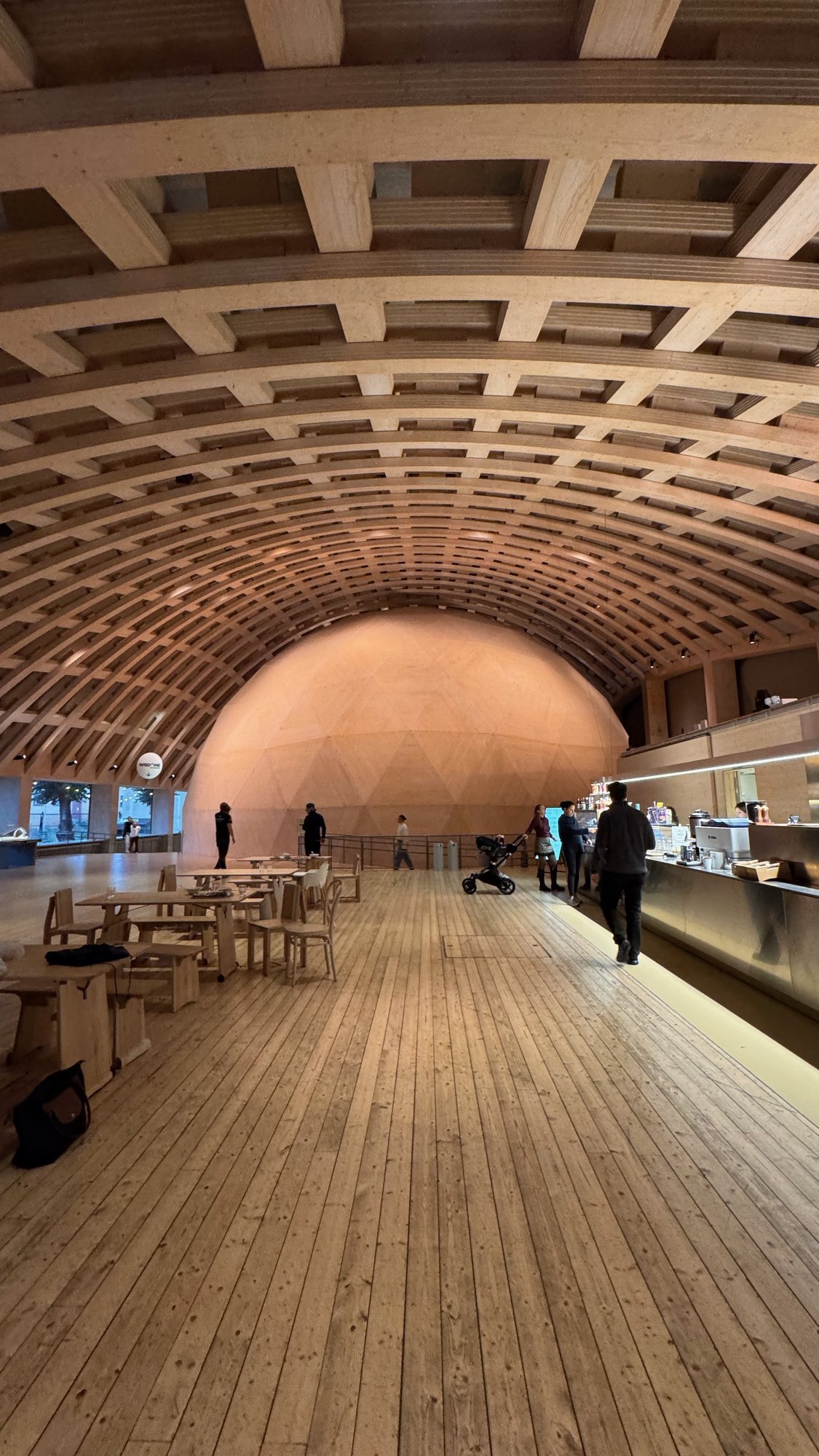 The round Wisdome dome under a wooden lattice roof at Tekniska museet.