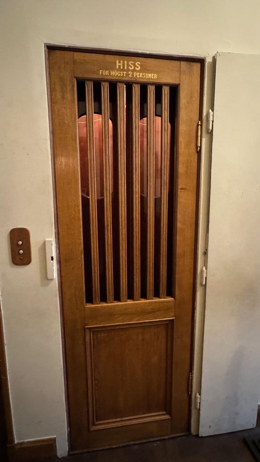 A wooden lift door with the text Hiss för högst 2 personer at the Hallwyl Museum.