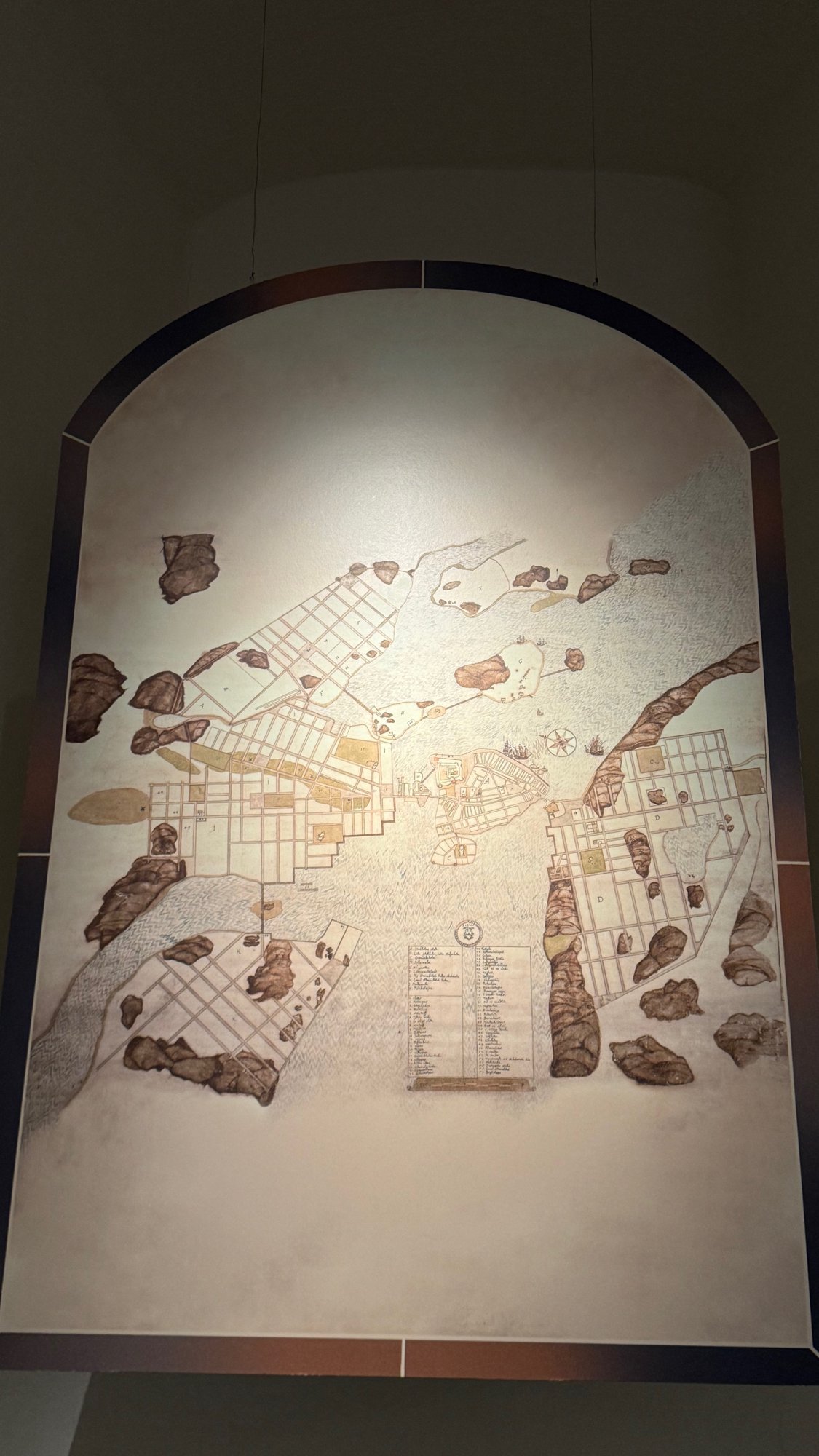 A large Danish map of Stockholm from the 1640s shown on an arched panel at the Stockholm City Museum.