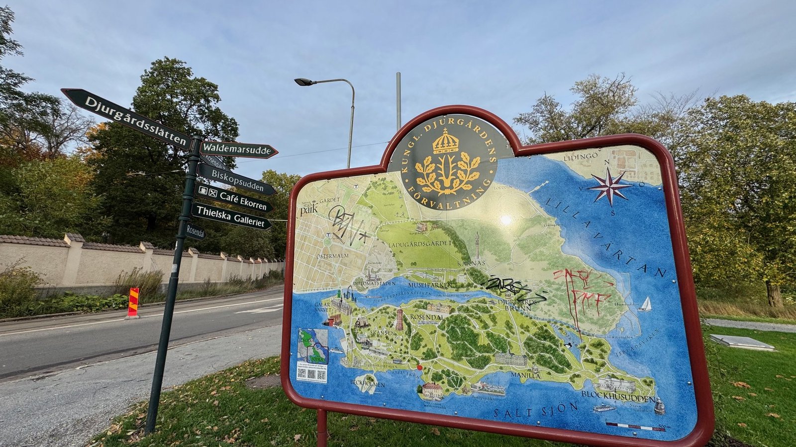 A large map of Djurgården and black signposts to Waldemarsudde and Thielska Galleriet by the road.