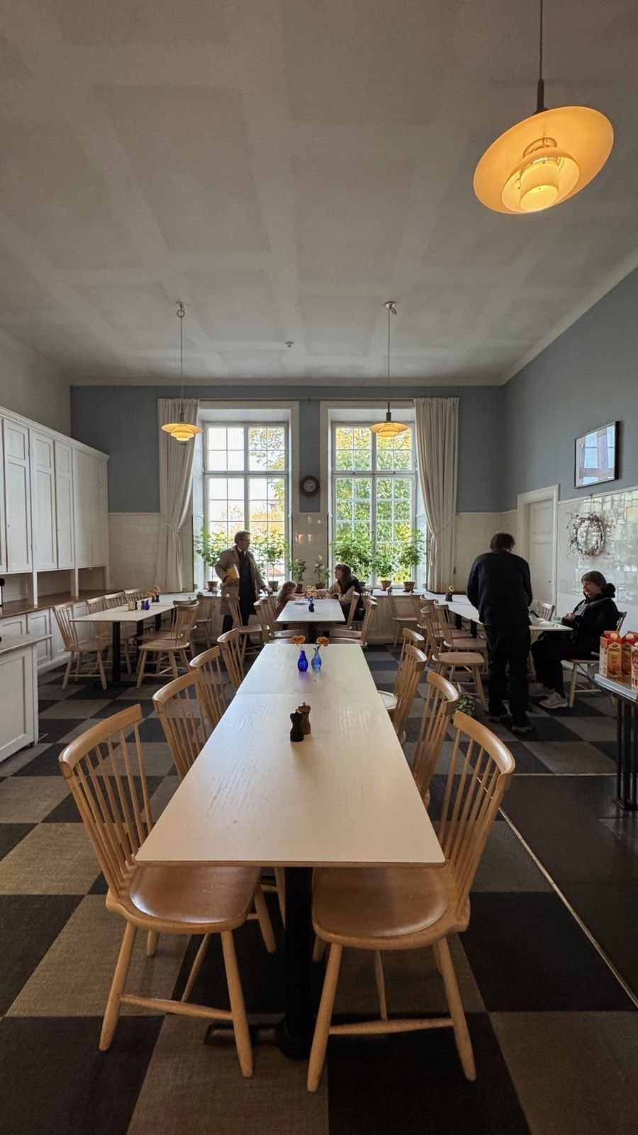 The restaurant Prinsens kök at Waldemarsudde with long tables, wooden chairs and tall windows.