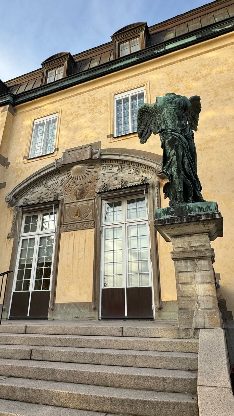 A bronze copy of the Winged Victory stands by the entrance steps of the Waldemarsudde mansion.