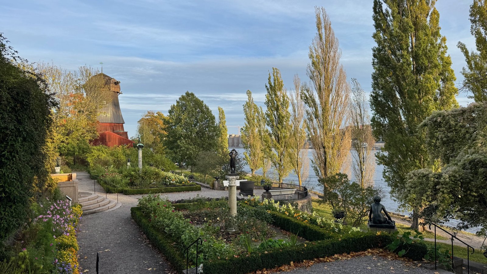 The terraced garden at Waldemarsudde with poplar trees, the old red mill and the water.