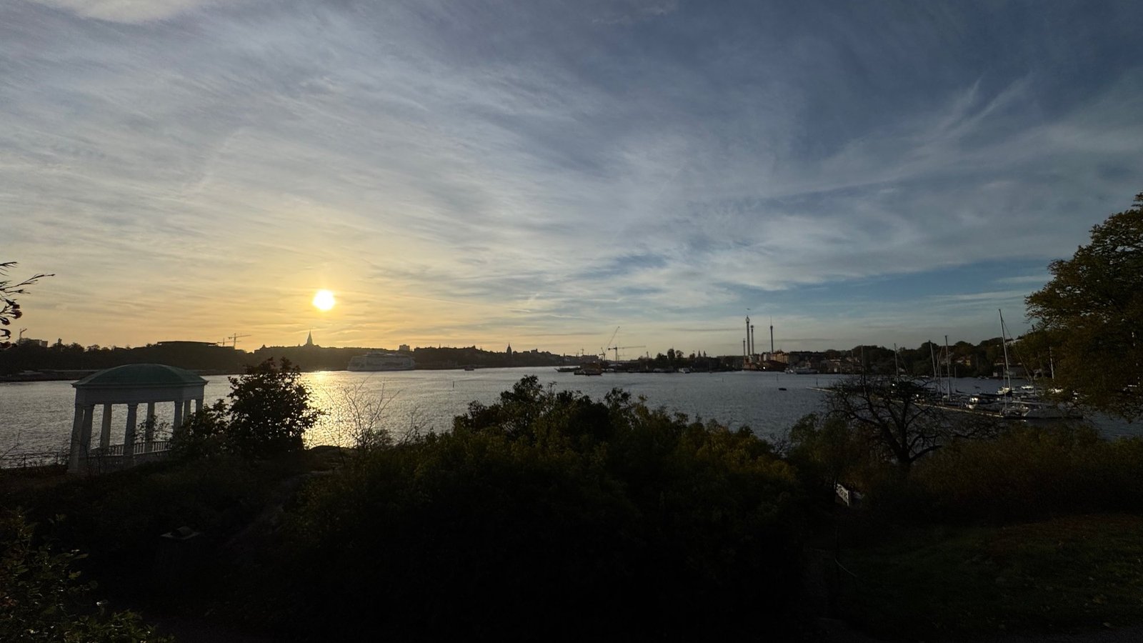 The sun sets over Saltsjön and the Stockholm skyline, seen from Waldemarsudde.
