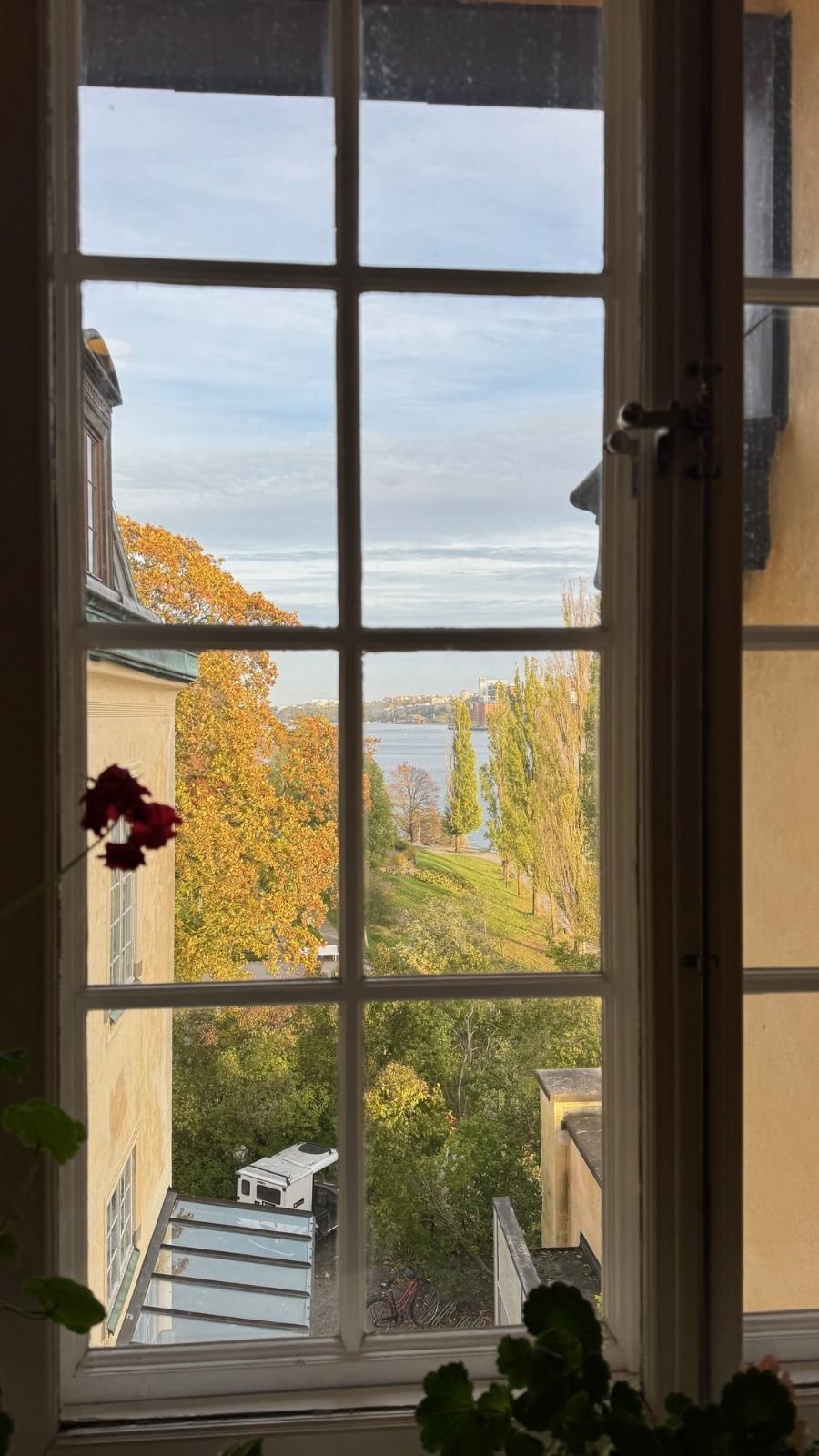 A tall window looks out on autumn trees and the water from the Waldemarsudde mansion.
