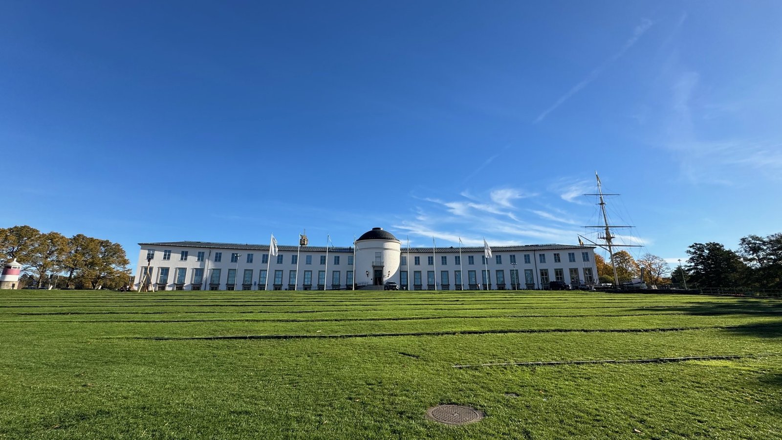 The long white building of Sjöhistoriska museet behind a green lawn.
