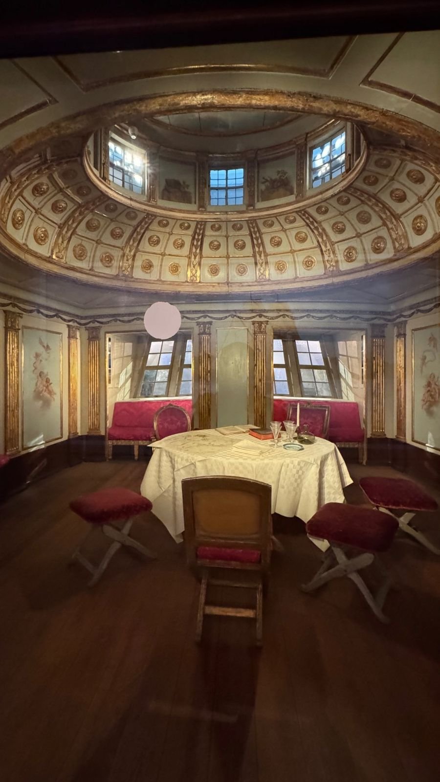 The royal cabin of Amphion with a round table and red chairs at Sjöhistoriska museet.