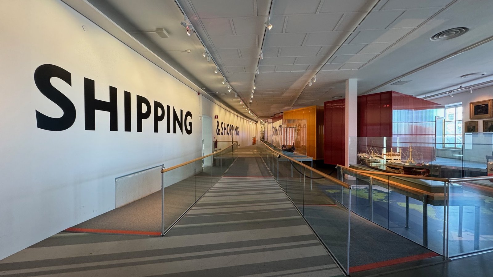 A long exhibition room with the word Shipping on the wall at Sjöhistoriska museet.