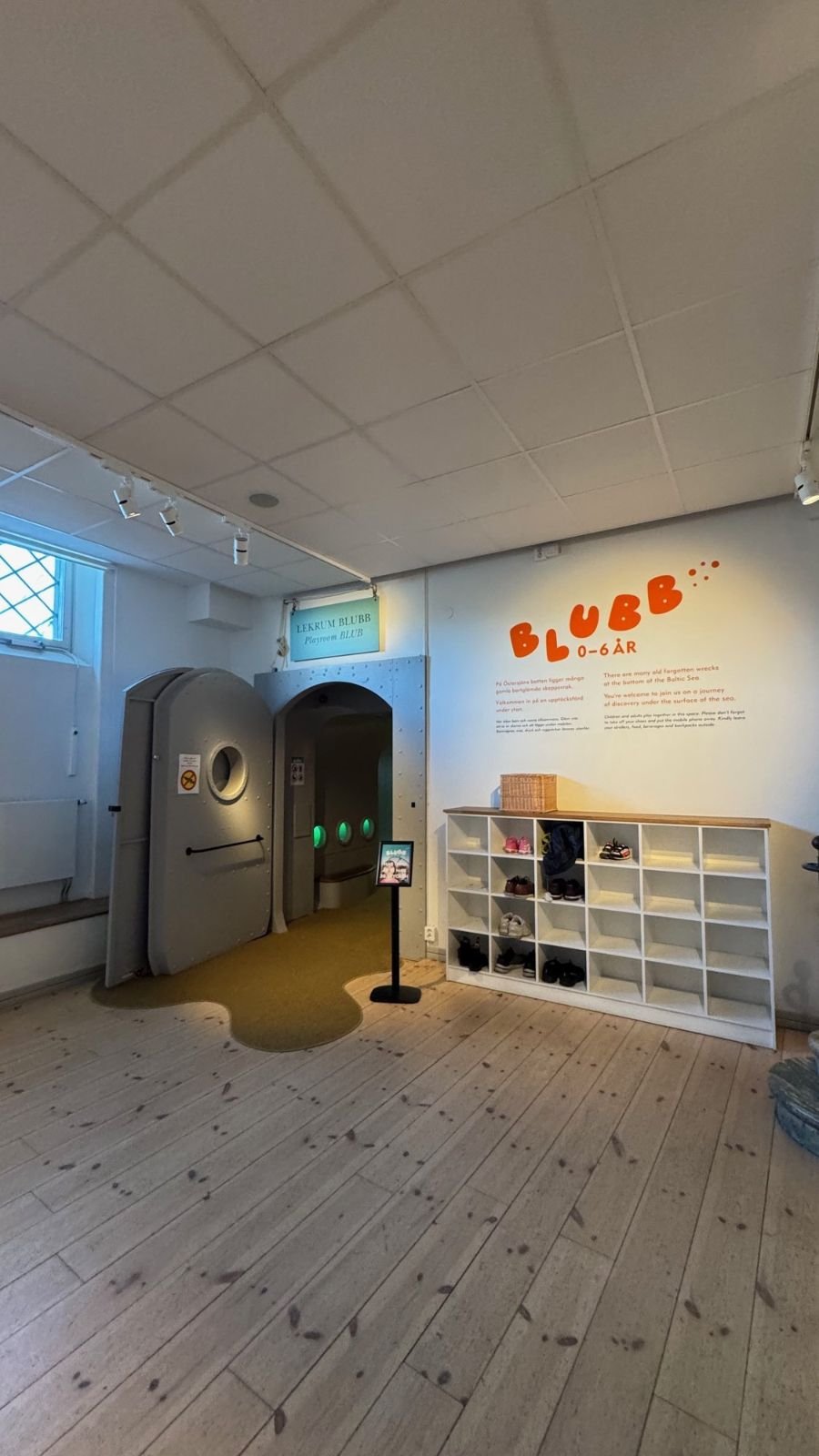 A children's area with a play door and shelves at Sjöhistoriska museet.
