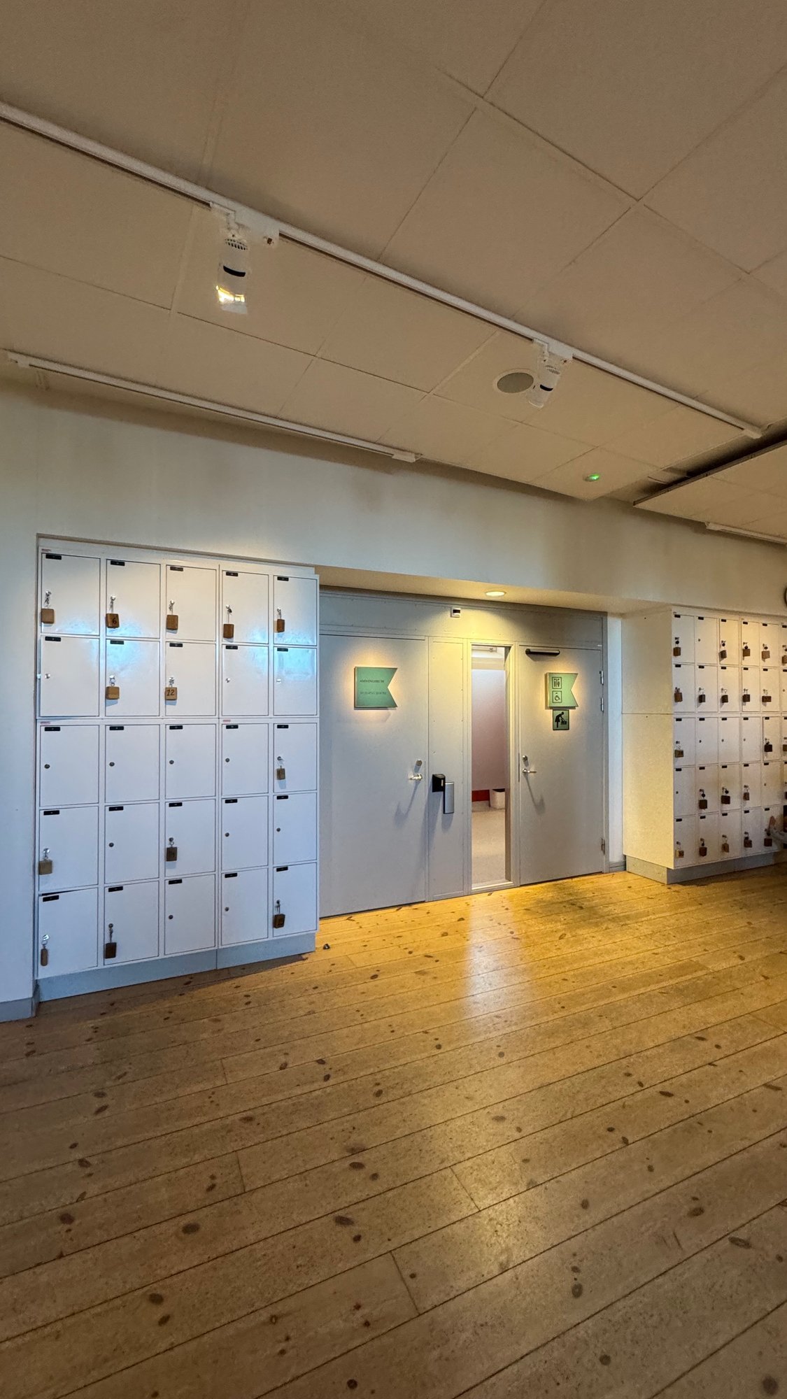 A room with white lockers and a wooden floor at Sjöhistoriska museet.