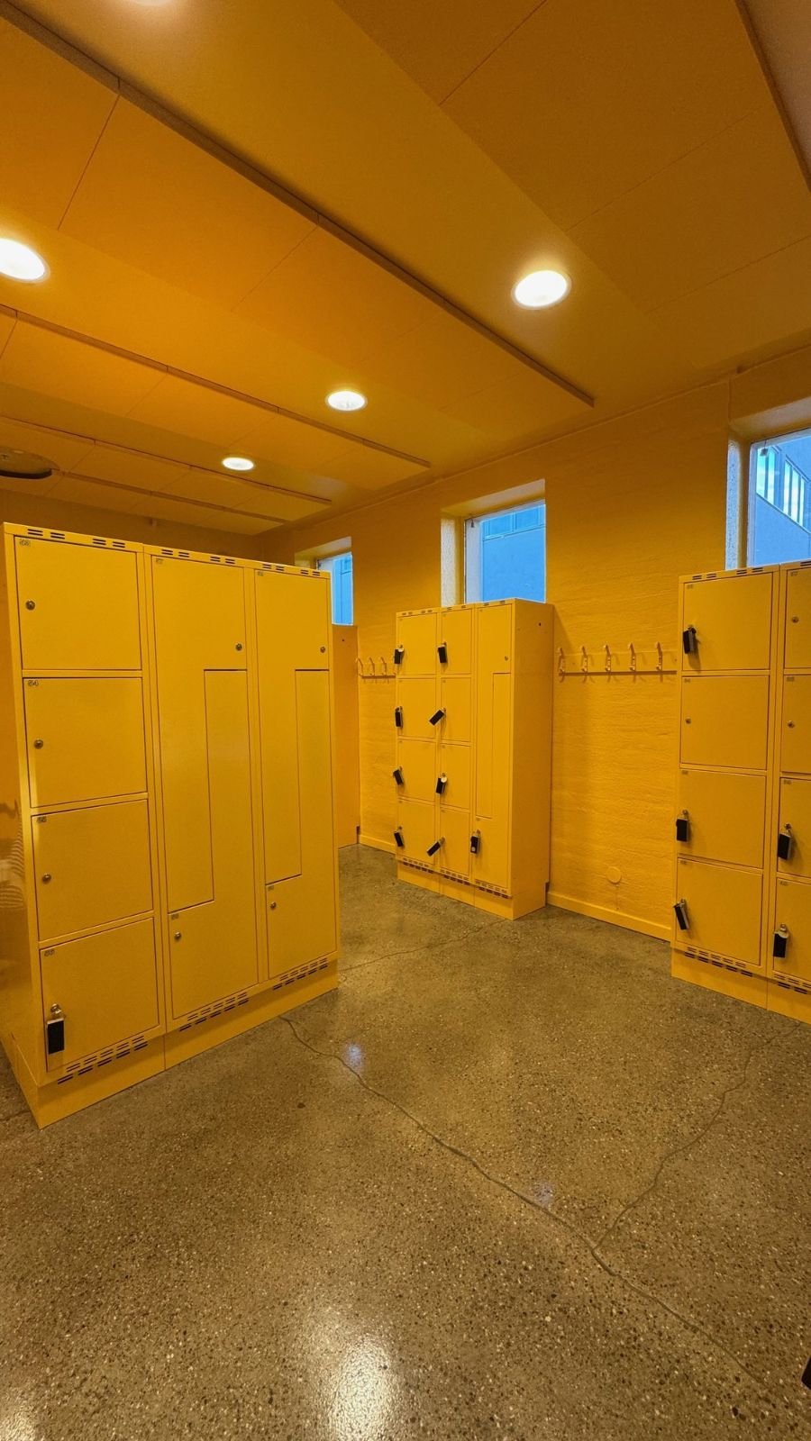 Rows of yellow lockers in a bright room at Polismuseet.