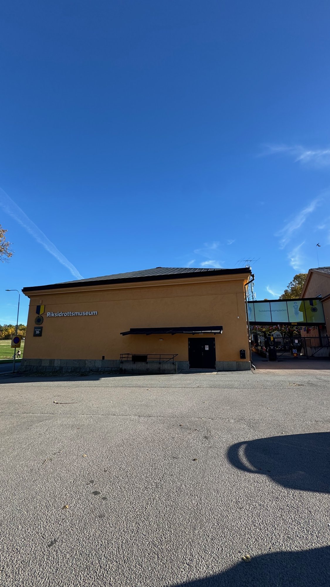 The yellow building of Riksidrottsmuseet under a blue sky.